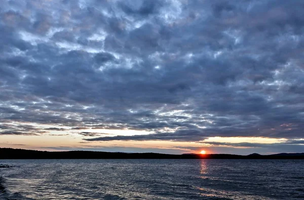 傍晚的天空笼罩着湖面 阳光照耀着云彩的剪影 — 图库照片