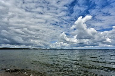 göl üzerinde mavi gökyüzü karşı gri ve beyaz cumulonimbus bulutlar