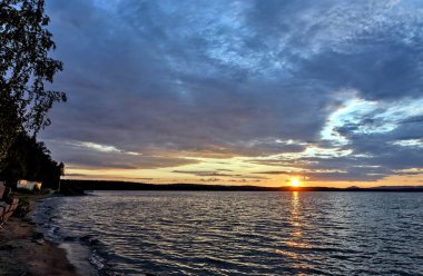 akşam gökyüzü göl güneş tarafından aydınlatılmış bulutlar siluetleri üzerinde