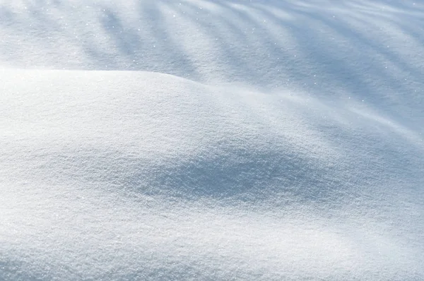 Frische Schneewehen, die von der Sonne mit Schatten beleuchtet werden — Stockfoto