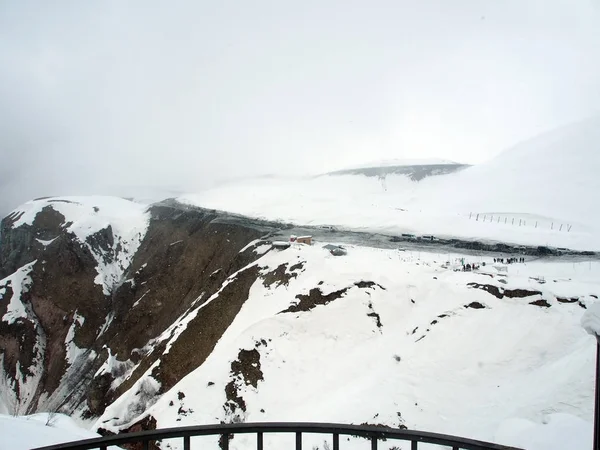Observation deck for tourists along the Georgian military road in spring during heavy snowfall — Stock Photo, Image
