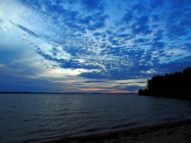 kaplumbağa kabuğu gibi küçük bulutlar ile göl üzerinde mavi günbatımı gökyüzü