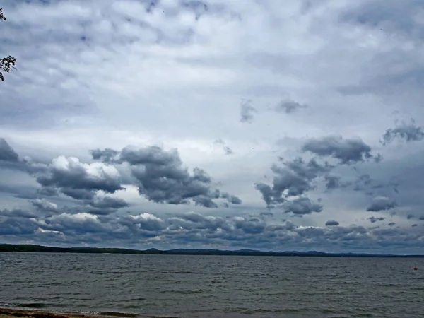 Sűrű, szürke felhők a tó felett felhős estéken — Stock Fotó