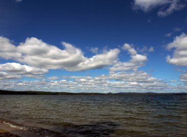 sabahın erken saatlerinde gölün üzerinde mavi gökyüzünde beyaz bulutlar