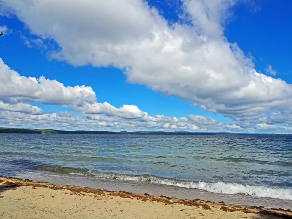 White clouds in the blue sky over the lake in the early morning — Stock Photo, Image