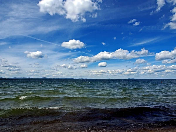 Langit biru gelap dengan awan cumulonimbus putih di atas danau pagi — Stok Foto