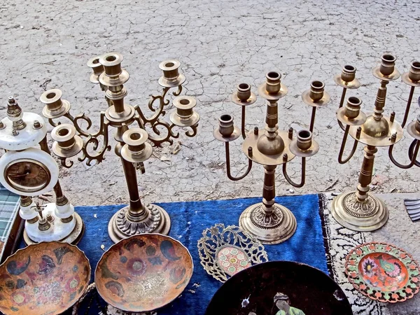 Διαφορετικά παλιά μεταλλικά αγαλματάκια, κηροπήγια, πιάτα και άλλα μικρά πράγματα στην υπαίθρια αγορά — Φωτογραφία Αρχείου