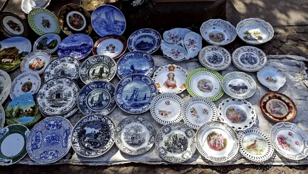 Placas de porcelana con hermosas imágenes en el mercado de pulgas — Foto de Stock