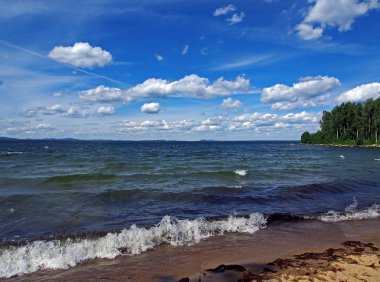 Koyu mavi gökyüzü ile beyaz kümülonimbus bulutları sabah gölünün üzerinde