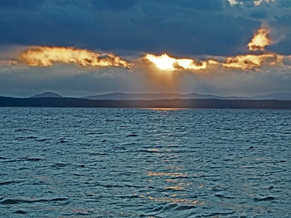 蓝色日落天空的橙色太阳，湖面上，乌拉尔南部有巨大的云彩 — 图库照片