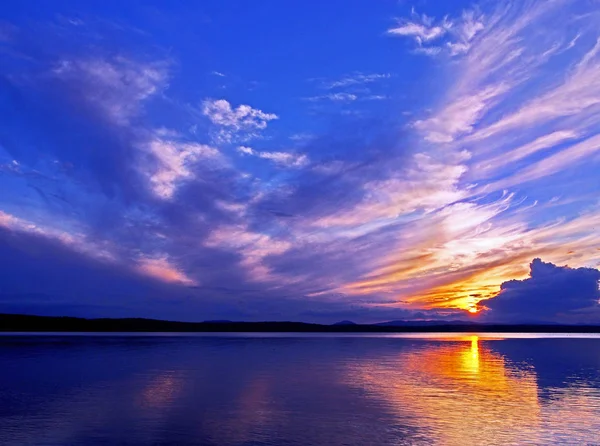 Cielo colorido puesta de sol azul y naranja sobre el lago, hora azul — Foto de Stock