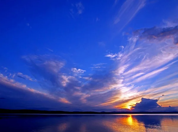 Cielo colorido puesta de sol azul y naranja sobre el lago, hora azul — Foto de Stock