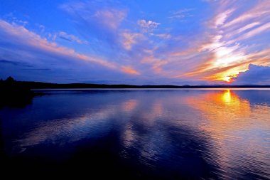 göl üzerinde renkli mavi ve turuncu günbatımı gökyüzü, mavi saat