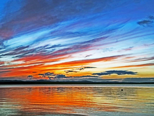 Cielo colorido puesta de sol azul y naranja sobre el lago, hora azul — Foto de Stock