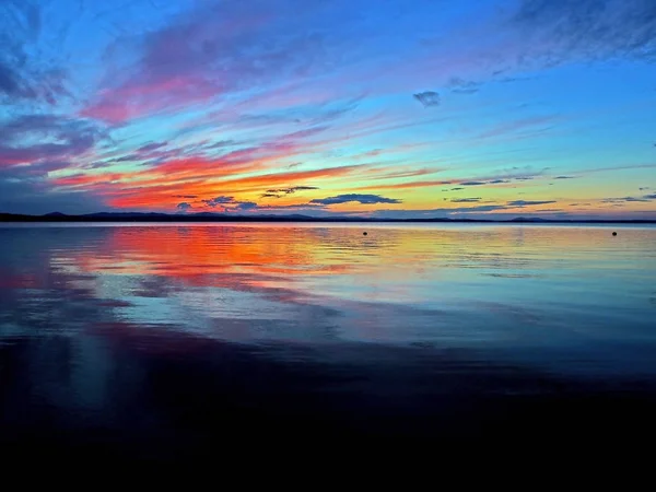 五颜六色的蓝色和橙色的日落天空在湖上，蓝色小时 — 图库照片