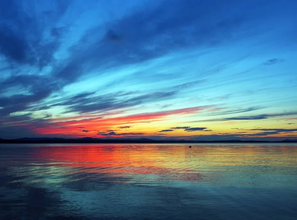 Farbenfroher blauer und orangefarbener Abendhimmel über dem See, blaue Stunde — Stockfoto