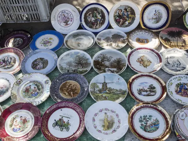 Placas de porcelana con hermosas imágenes en el mercado de pulgas — Foto de Stock