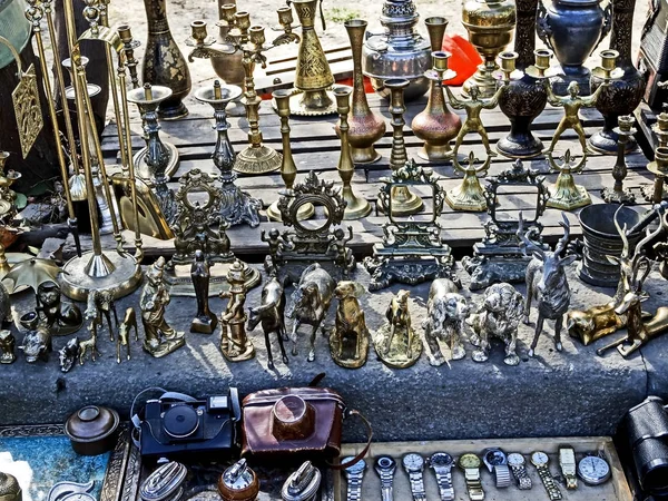 Verschiedene alte Metallfiguren, Kerzenständer, Geschirr und andere Kleinigkeiten auf dem Flohmarkt — Stockfoto