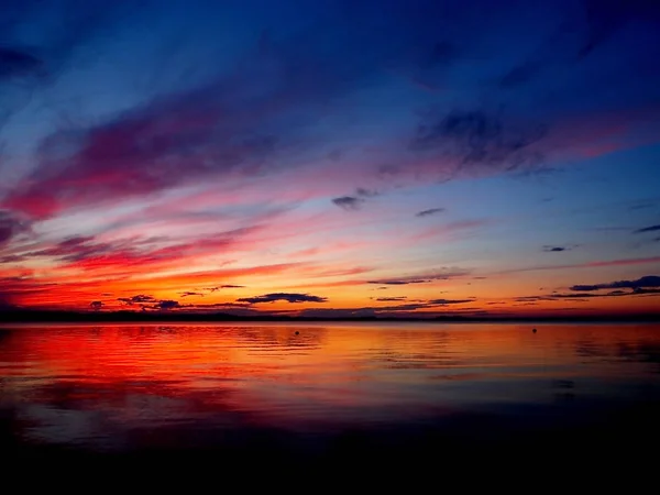 Röd solnedgång himmel över sjön, dramatisk belysning — Stockfoto