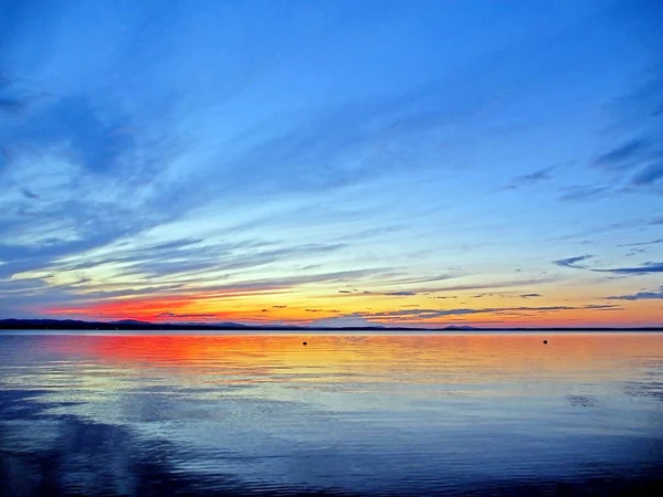 五颜六色的蓝色和橙色的日落天空在湖上，蓝色小时 — 图库照片