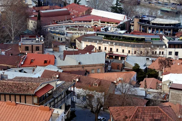 Διάφορες, χρωματιστές, όμορφες στέγες της πόλης Τιφλίδα φωτισμένες από τον απαλό βραδινό ήλιο — Φωτογραφία Αρχείου