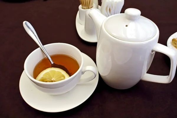 Tea in a mug with a teaspoon and lemon — Stock Photo, Image