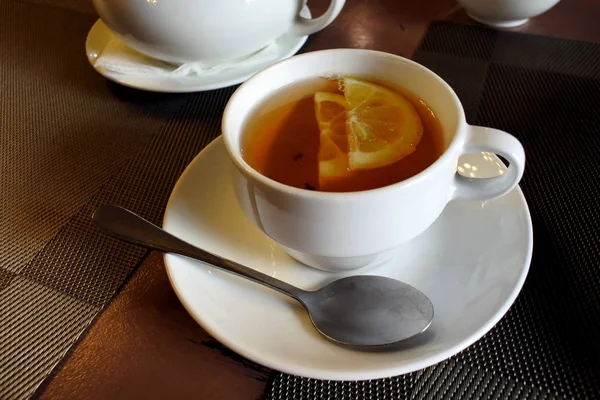 Tea in a mug with a teaspoon and lemon — Stock Photo, Image