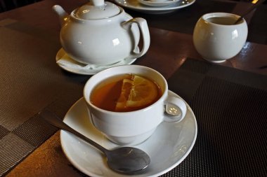 bir çay kaşığı ve limon ile bir kupa çay