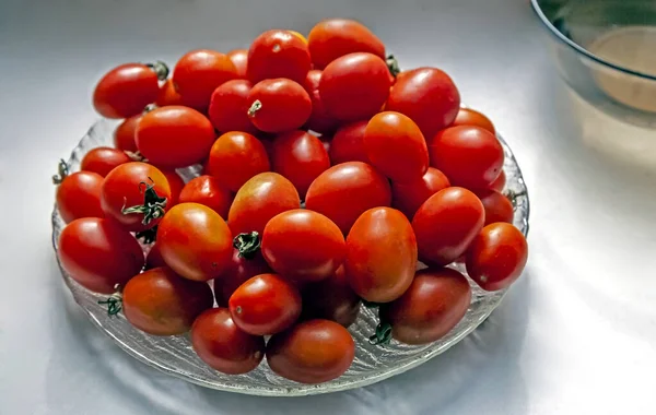 Red fresh small tomatoes in a glass plate — Stock Photo, Image
