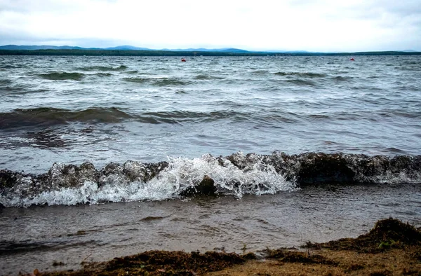 Våg rullar över sandstranden av sjön Uvildy — Stockfoto