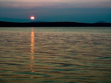 Günbatımı turuncu güneş gölün üzerinde, alacakaranlık geliyor, sonbahar