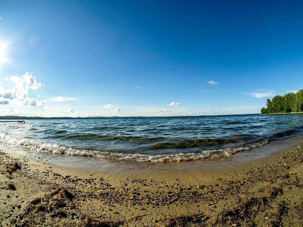 Gölün kıyısı, kum, dalgalar, açık renkli mavi gökyüzü, balık gözü merceği, Uvildy Gölü, Güney Urallar