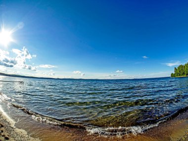Gölün kıyısı, kum, dalgalar, açık renkli mavi gökyüzü, balık gözü merceği, Uvildy Gölü, Güney Urallar
