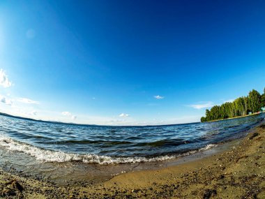 Gölün kıyısı, kum, dalgalar, açık renkli mavi gökyüzü, balık gözü merceği, Uvildy Gölü, Güney Urallar