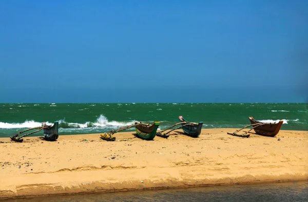 Geleneksel Srilankan tekneler-bir kum plajında Katamaran, arka plan yeşil okyanus ve mavi gökyüzü ile; , Sri Lanka.            