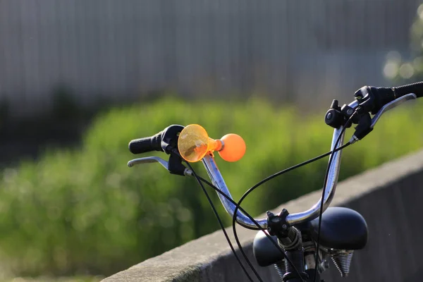 Крупный План Ярко Оранжевый Велосипедный Гонг Руле Зеленом Фоне Травы — стоковое фото