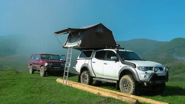 İle çadır çatı ve kırmızı cip sabah sis ve güneşli blu gökyüzü arka plan üzerinde beyaz off-road jeep.