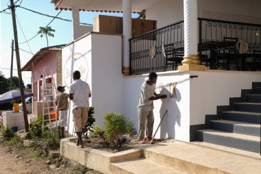 Zanzibar, Tanzanya. 24 Temmuz 2018: Üç siyah adam altın boya ile Restoran cephe dekorasyon nişanlandık