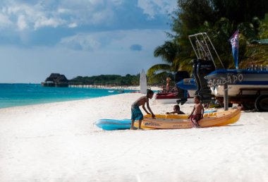 Güneşli bir günde bir tekne plajında oynayın üç koyu tenli çocuklar. Hint Okyanusu kıyısında. Zanzibar, Tanzanya
