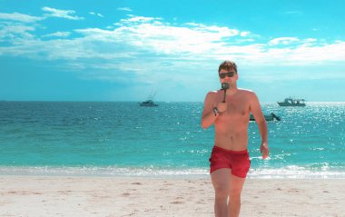 Sahilde genç adam kameraya Zanzibar bildiriyor