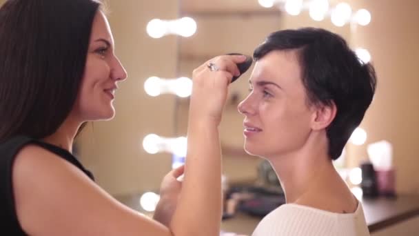 粉底膏应用中的造型与化妆艺术家微笑 — 图库视频影像