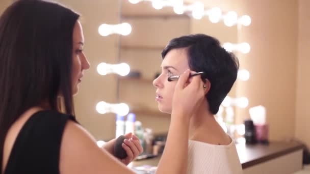 Maquillador Comunica Alegremente Con Chica Sombreando Polvo — Vídeo de stock