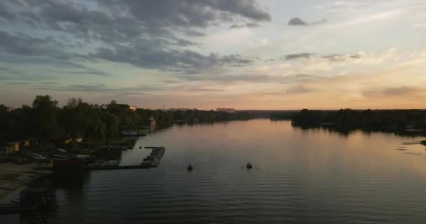 Vol par drone au-dessus des pêcheurs et de la station de bateau, au coucher du soleil sur la rivière. Beau ciel — Video