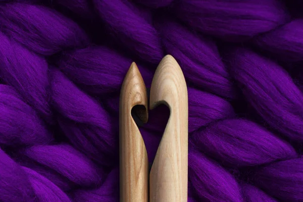 Two knitting needles with a cut in the form of a heart, lying on a merino wool, handmade, purple — Stock Photo, Image