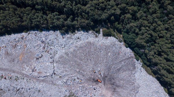 Вид с высоты птичьего полета на экологическую катастрофу, мусорная свалка на границе с лесом