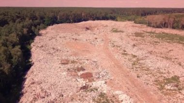 Ukrayna 'daki çöplüklerden oluşan dağlarla birlikte ormanın etrafındaki çöplüğün üzerinden uçuyor. Çevresel sorun, teknolojik arıza, felaket