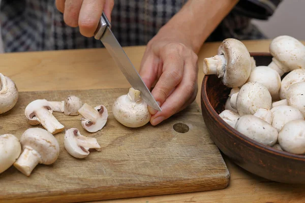 Woman cutting champignons. Cooking with champignons. Selective focus.