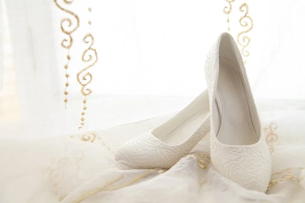 半透明の布に白い女性の結婚式の靴 — ストック写真