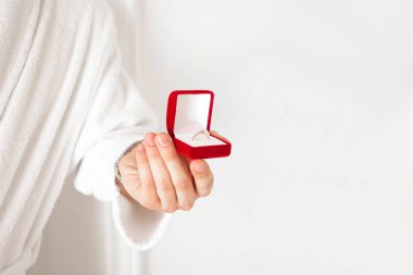 Evlenme teklifi. El ile bir altın rin bir kırmızı hediye kutusu tutar