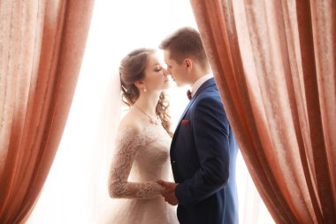 düğün. Gelin ve damat pencerenin önünde, elele, birbirimiz için ulaşan duruyorsun